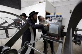 רבנים חרדים בירושלים בודקים מכונה לטחינת קמח למצות. צילום: קובי גדעון, פלאש 90