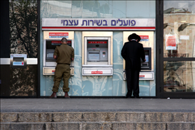 חרדי וחייל מושכים כסף בירושלים. צילום: פלאש 90
